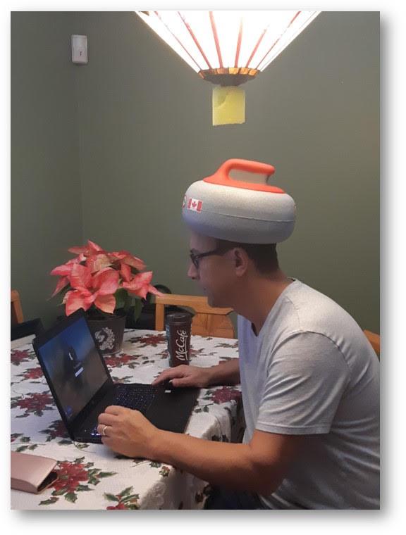 tim favacho sitting at table with curling rock hat on
